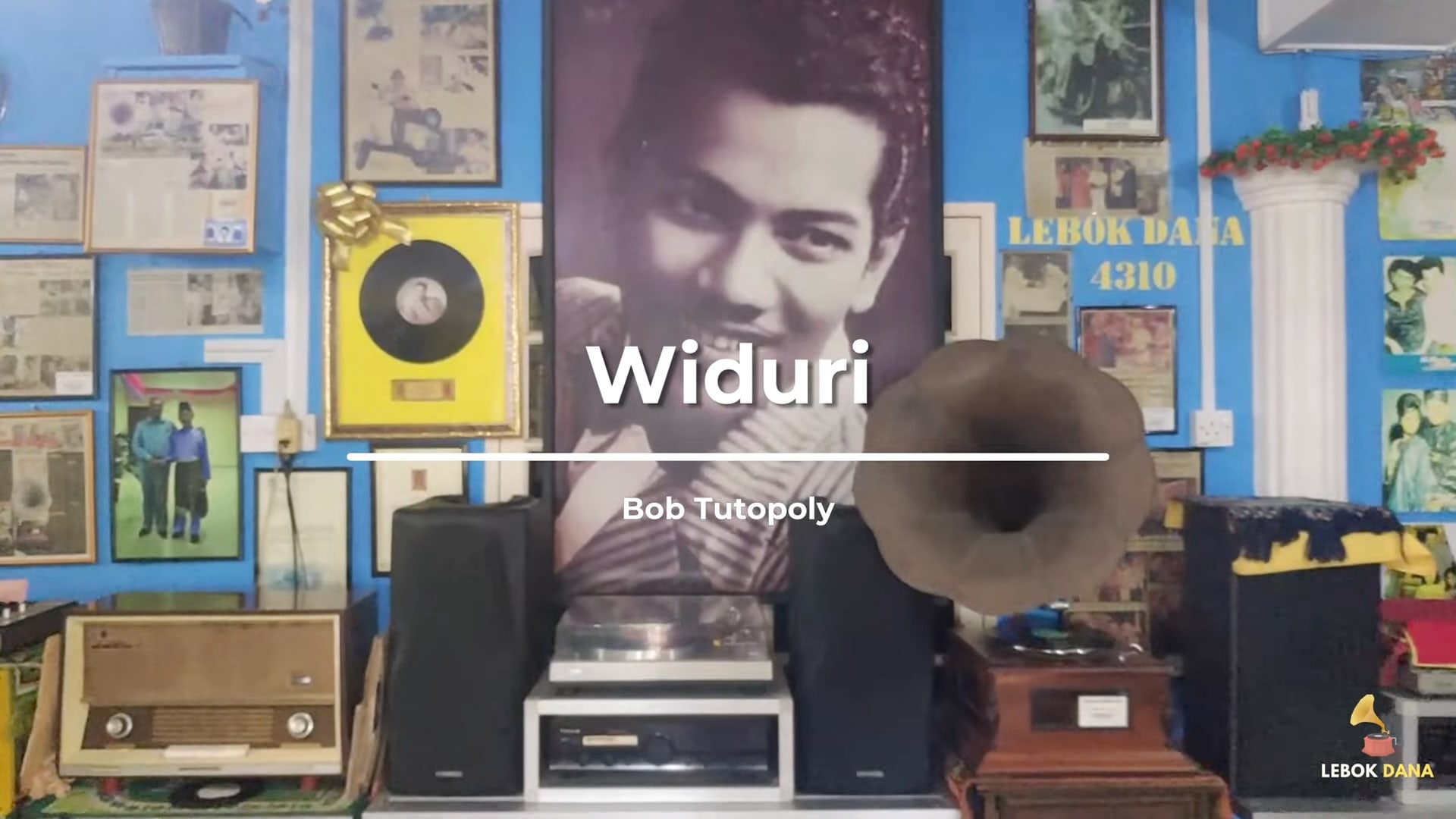 Kad tajuk video Widuri nyanyian Bob Tutupoly, berlatarkan dinding Galeri Lebok Dana dengan potret P. Ramlee, piring hitam berbingkai dan gramofon